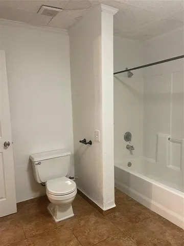 a white toilet sitting next to a bath tub