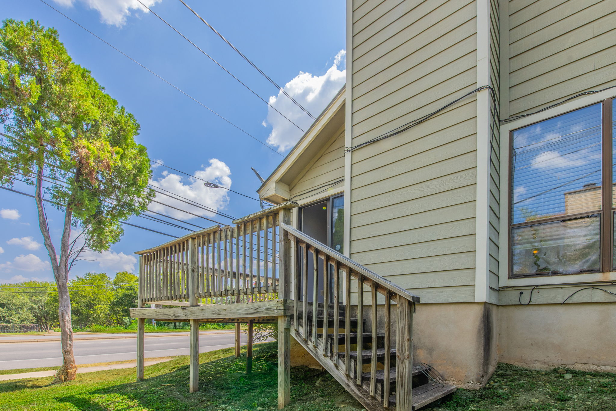 2000 Kenneth Avenue, Unit B Austin, TX 78741 - Photo 21 of 22 A raised wooden deck with railings extends from the home's exterior, offering outdoor access.