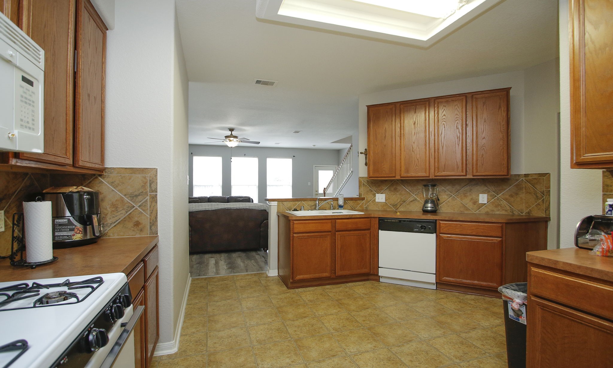 1031 Spring Heights Drive Spring, TX 77373 - Photo 15 of 41 a kitchen with stainless steel appliances granite countertop a stove top oven a sink a dining table and chairs with wooden floor