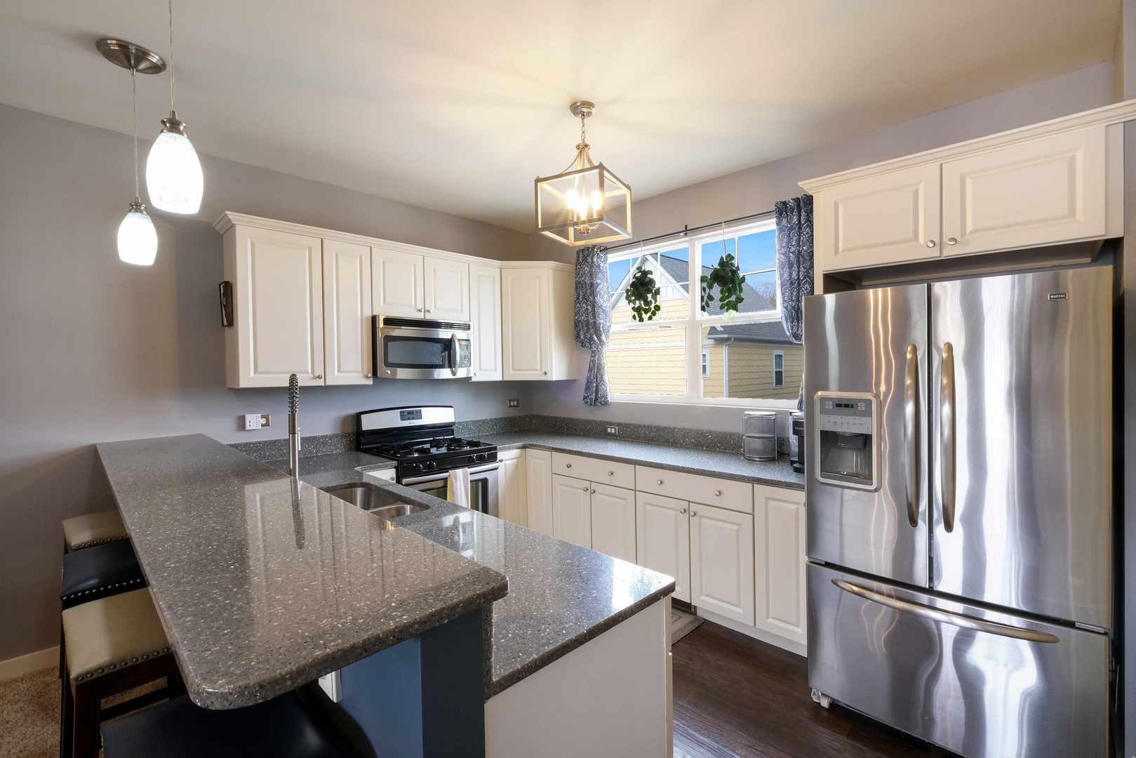 5 River Row Ottawa, IL 61350 - Photo 15 of 24 a kitchen with stainless steel appliances granite countertop a refrigerator a stove a sink dishwasher a dining table and chairs with wooden floor