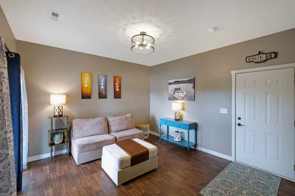 a living room with furniture and a wooden floor