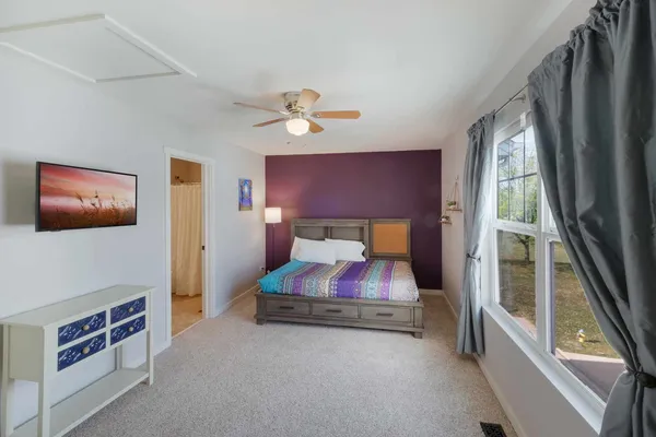 a spacious bedroom with a bed and a large window