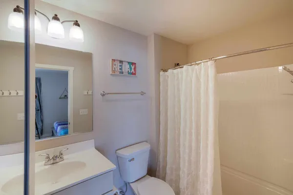 a bathroom with a sink a toilet and shower curtain