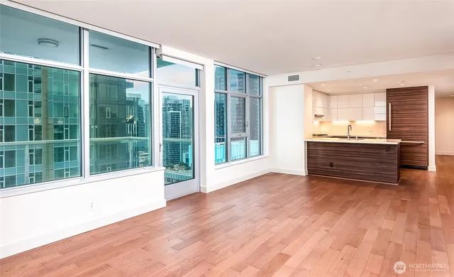 a view of a room with wooden floor and windows