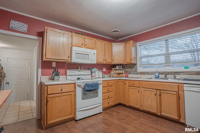 a kitchen with sink cabinets and wooden floor