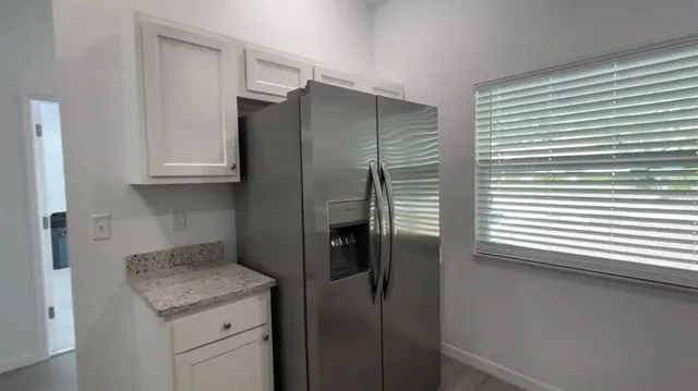 a kitchen with a granite countertop sink and refrigerator
