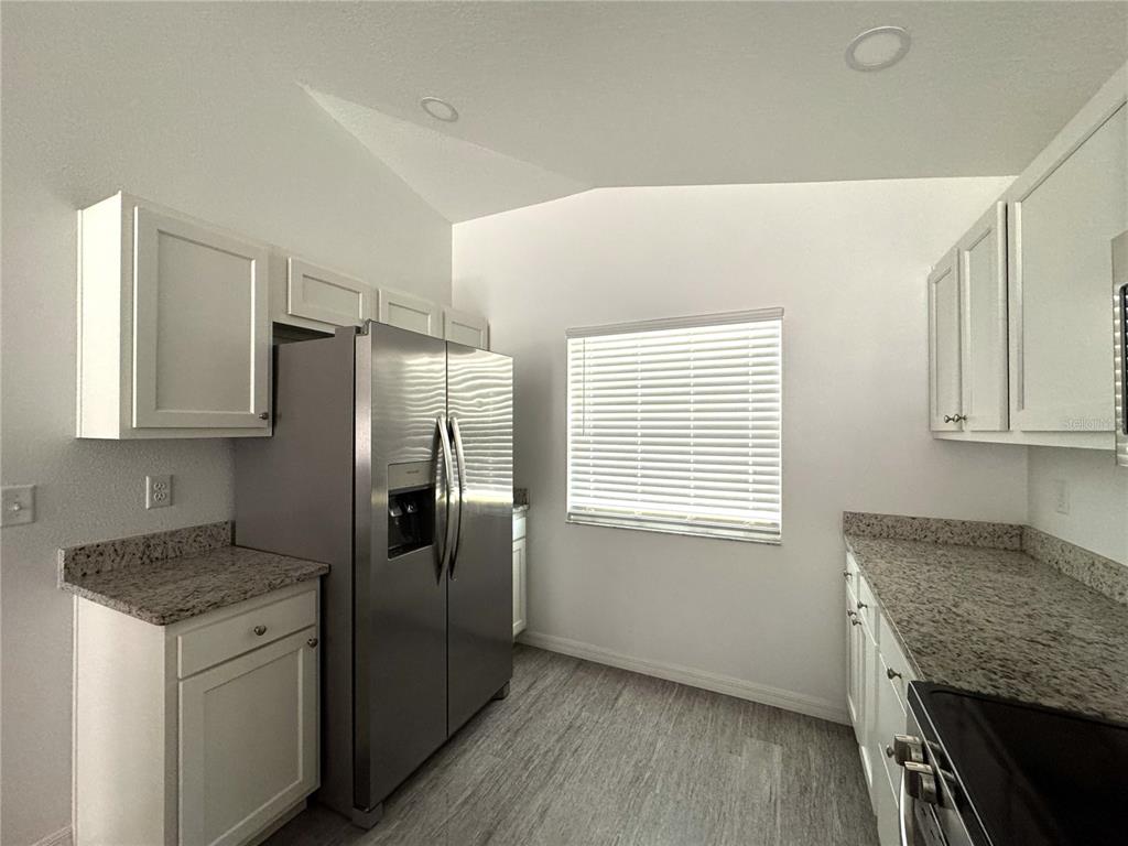6386 East Rush Street Inverness, FL 34452 - Photo 7 of 21 a kitchen with stainless steel appliances granite countertop a refrigerator and a stove