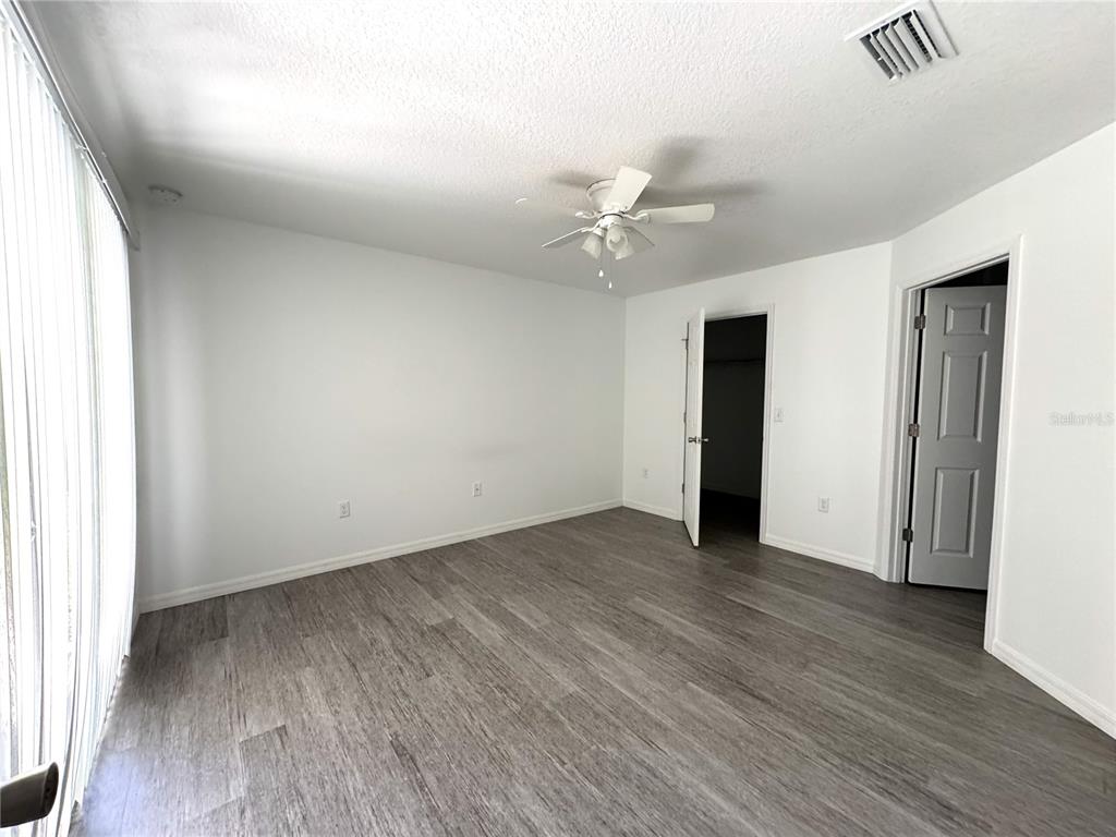 6386 East Rush Street Inverness, FL 34452 - Photo 9 of 21 an empty room with wooden floor and ceiling fan