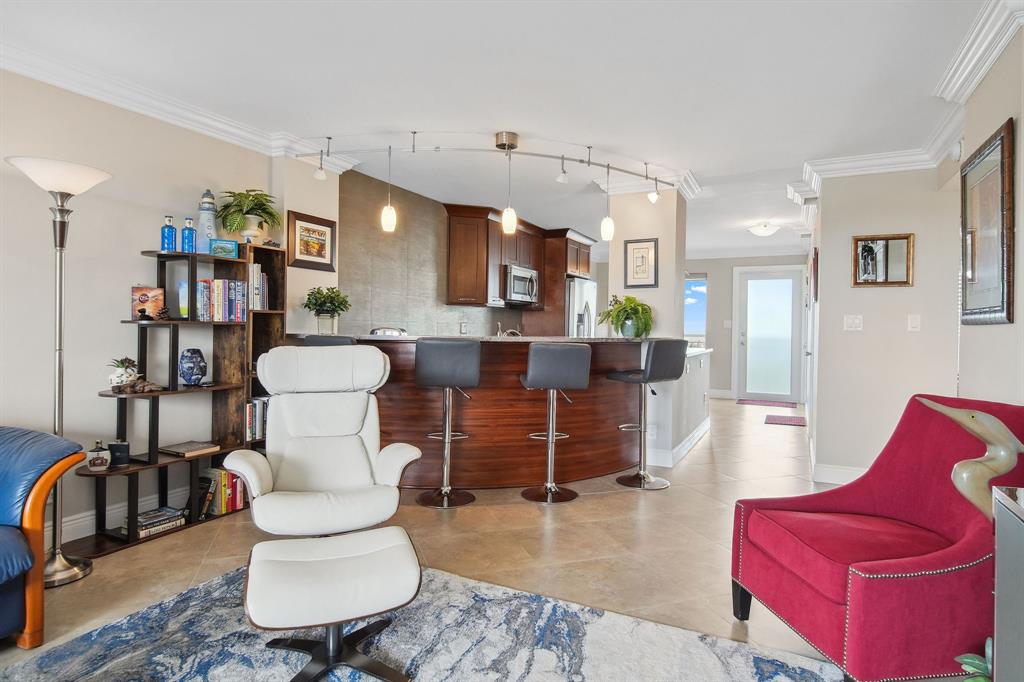 2611 North Riverside Drive, Unit 1106 Pompano Beach, FL 33062 - Photo 11 of 28 a living room with furniture a rug and a lamp