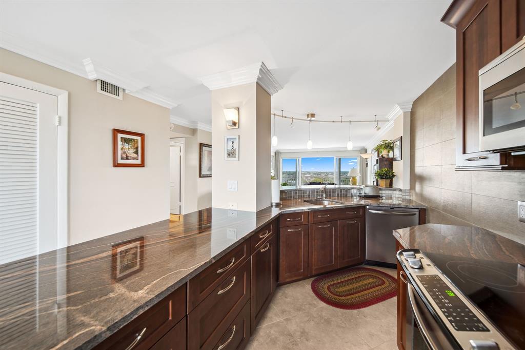 2611 North Riverside Drive, Unit 1106 Pompano Beach, FL 33062 - Photo 8 of 28 a open kitchen with stainless steel appliances granite countertop a sink and stove
