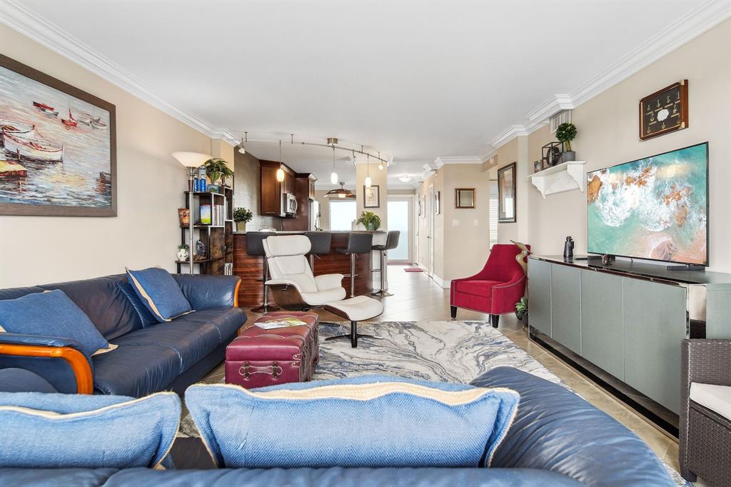 2611 North Riverside Drive, Unit 1106 Pompano Beach, FL 33062 - Photo 10 of 28 a living room with furniture and a flat screen tv