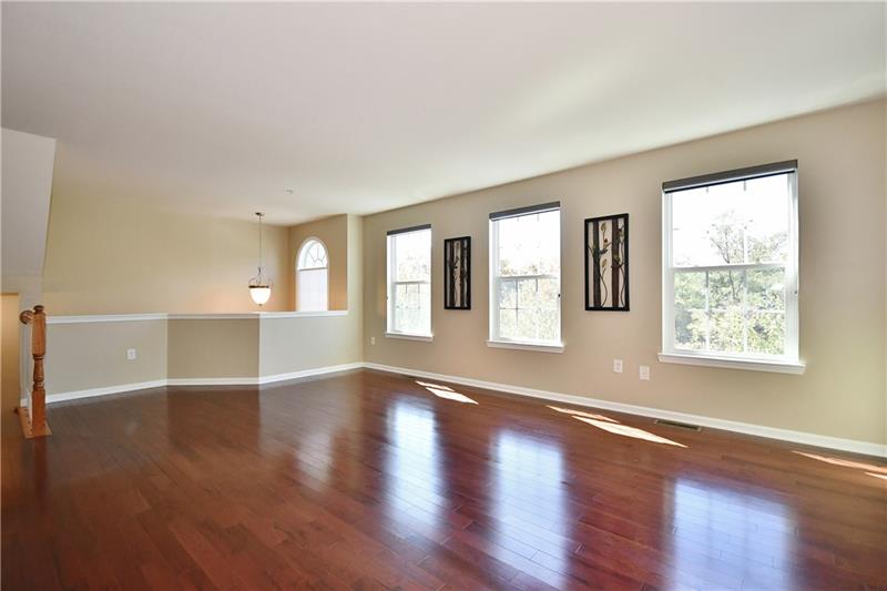 The living room is bright with the natural light from the windows. Look at how those hardwood floors gleam!
