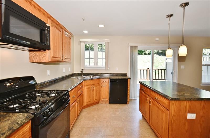 This eat-in kitchen has it all with natural oak cabinets and high-def counters. 