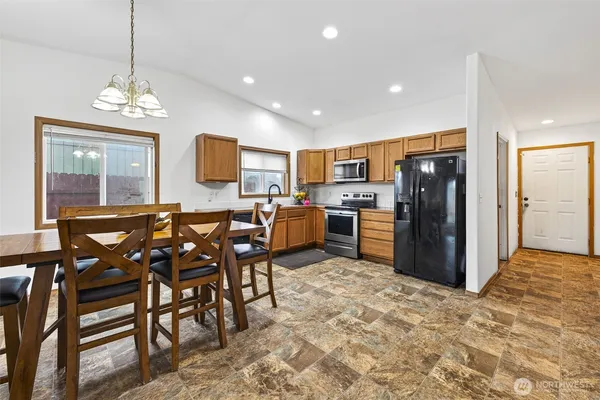a kitchen with stainless steel appliances granite countertop a refrigerator and a stove top oven