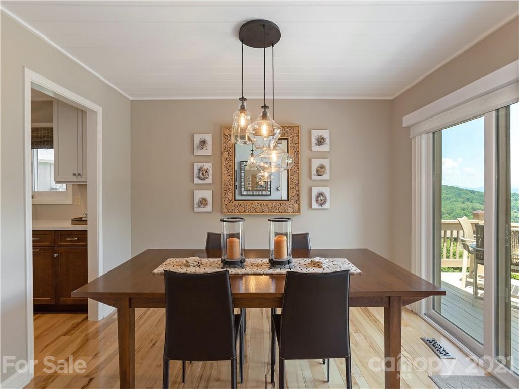 116 Country Ridge Road Laurel Park, NC 28739 - Photo 12 of 26 a view of a dining room with furniture a chandelier and wooden floor