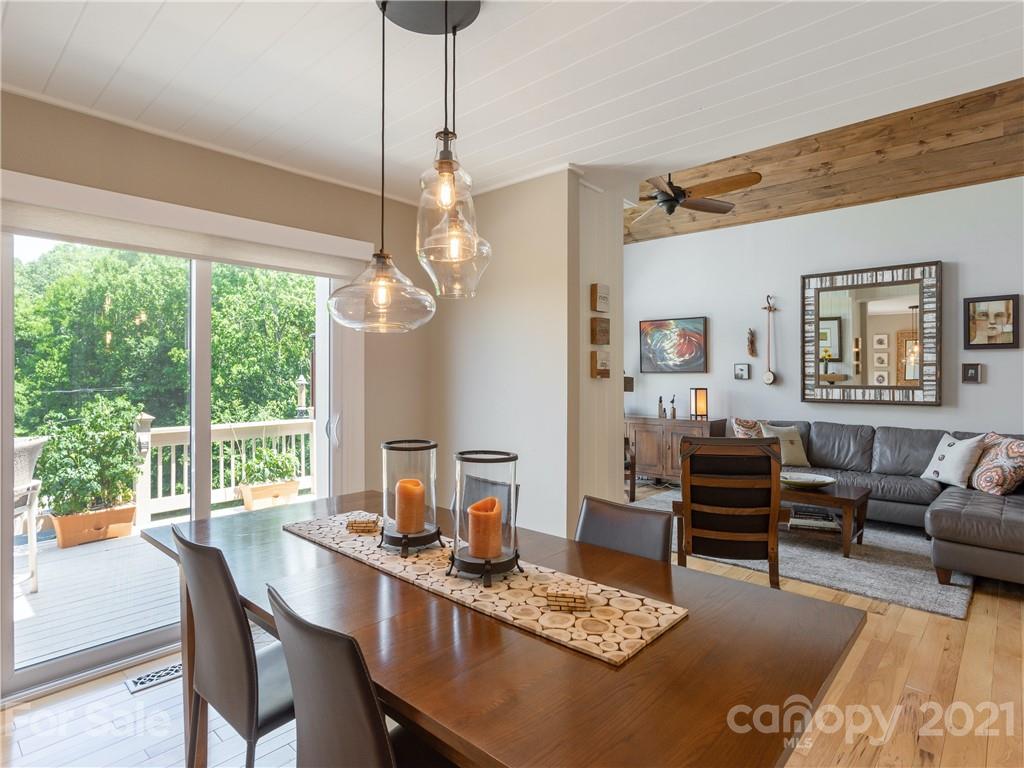 116 Country Ridge Road Laurel Park, NC 28739 - Photo 13 of 26 a dining room with wooden floor a chandelier a wooden table and chairs