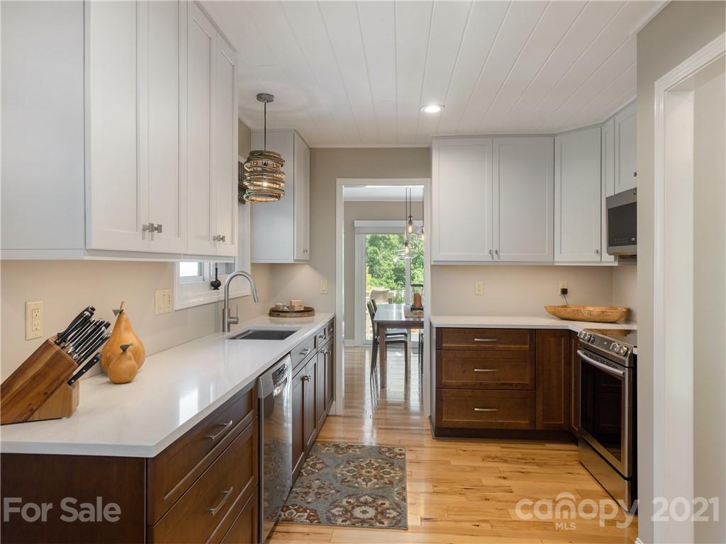 116 Country Ridge Road Laurel Park, NC 28739 - Photo 14 of 26 a kitchen with stainless steel appliances granite countertop a stove a sink and a refrigerator