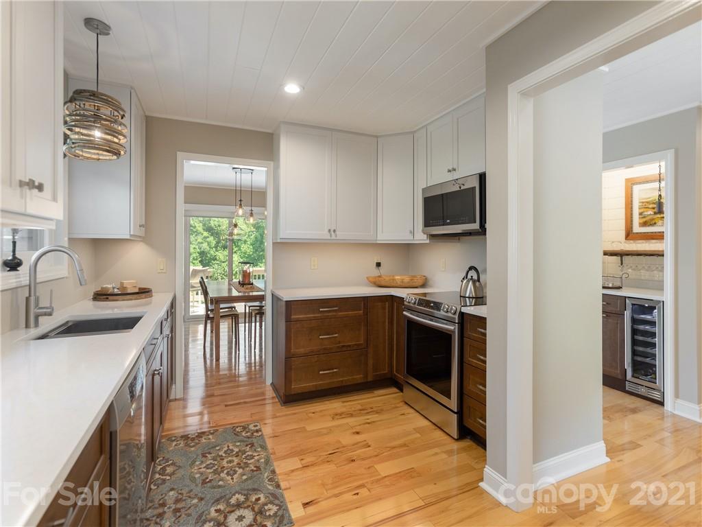 116 Country Ridge Road Laurel Park, NC 28739 - Photo 15 of 26 a kitchen with stainless steel appliances granite countertop a stove top oven a sink a dining table and chairs