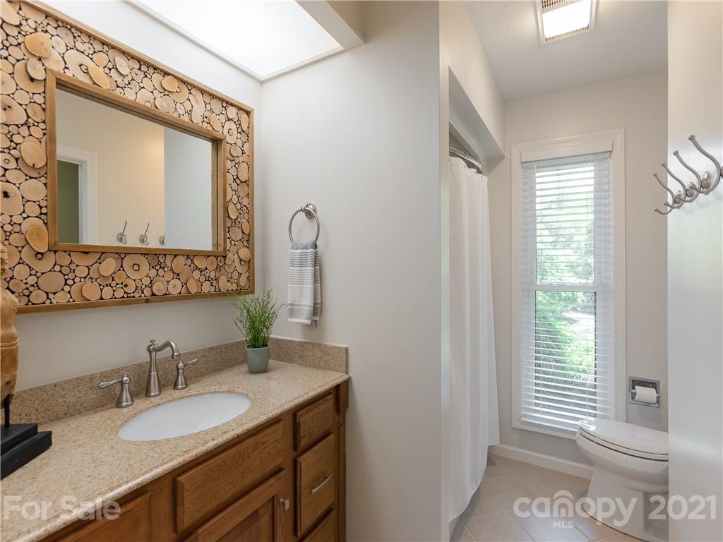 116 Country Ridge Road Laurel Park, NC 28739 - Photo 23 of 26 a bathroom with a granite countertop sink vanity mirror and a toilet