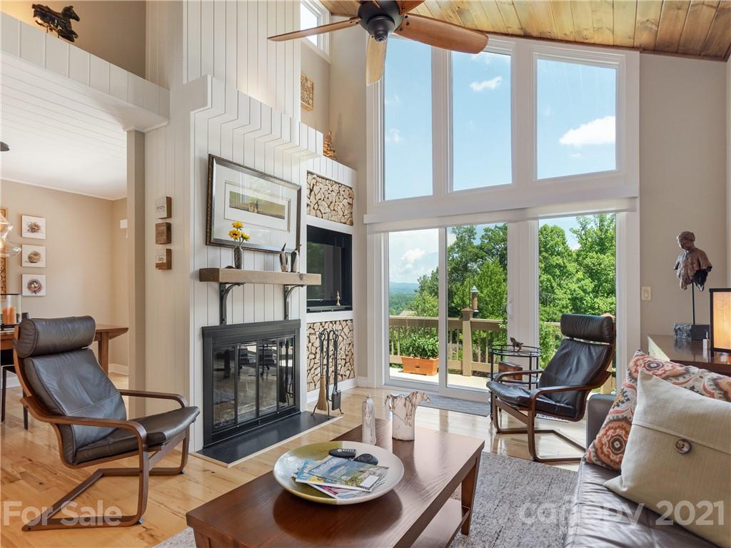 116 Country Ridge Road Laurel Park, NC 28739 - Photo 7 of 26 a living room with furniture a fireplace and floor to ceiling windows