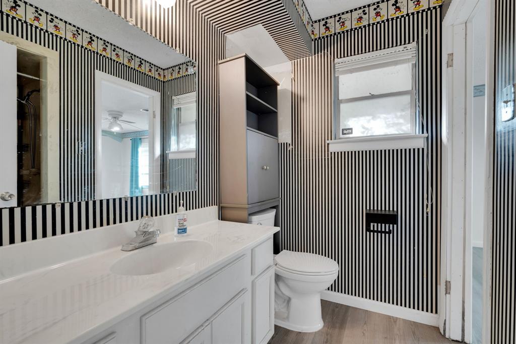 1320 Apache Street Arlington, TX 76012 - Photo 21 of 27 a bathroom with a toilet a sink and mirror