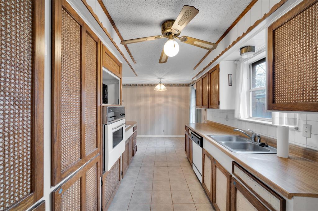 1320 Apache Street Arlington, TX 76012 - Photo 9 of 27 a kitchen with stainless steel appliances a sink and cabinets