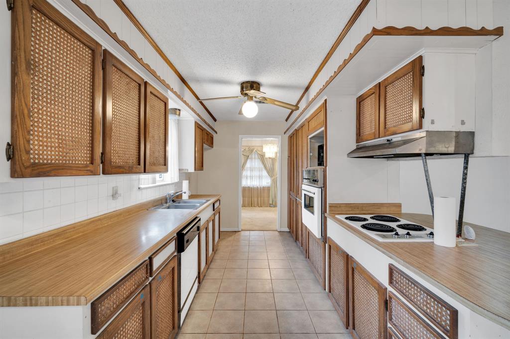 1320 Apache Street Arlington, TX 76012 - Photo 10 of 27 a kitchen with stainless steel appliances granite countertop a sink and a stove