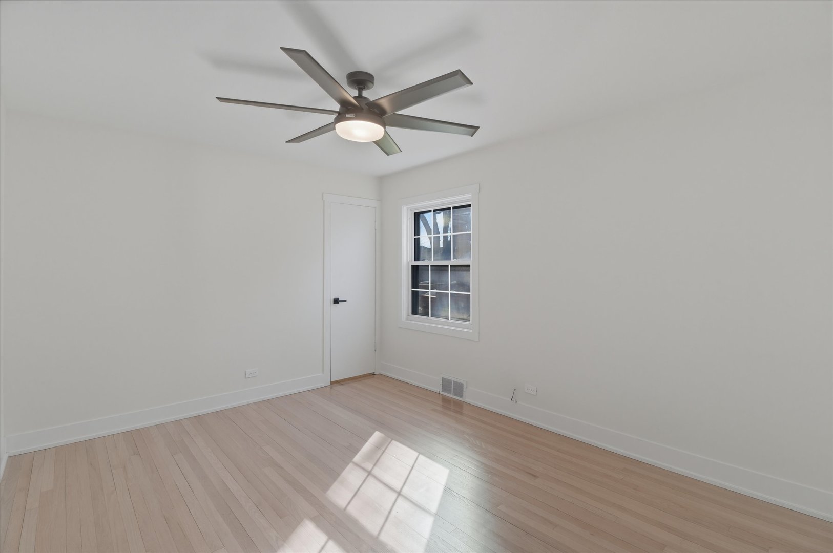 7230 South Avers Avenue Chicago, IL 60629 - Photo 25 of 44 an empty room with wooden floor fan and windows