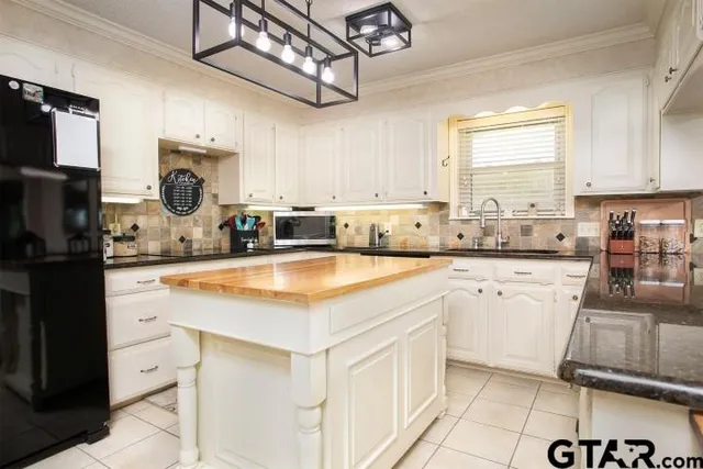 a kitchen with stainless steel appliances granite countertop a sink a stove cabinets counter space and a window