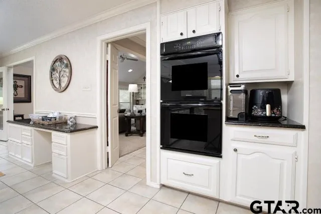 a kitchen with granite countertop white cabinets and stainless steel appliances