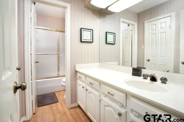 a bathroom with a double vanity sink a mirror and a shower