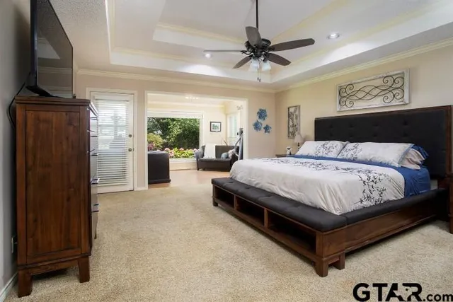 a bedroom with a large bed a flat tv screen and dresser
