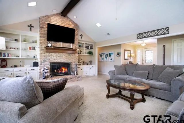 a living room with furniture a flat screen tv and a fireplace