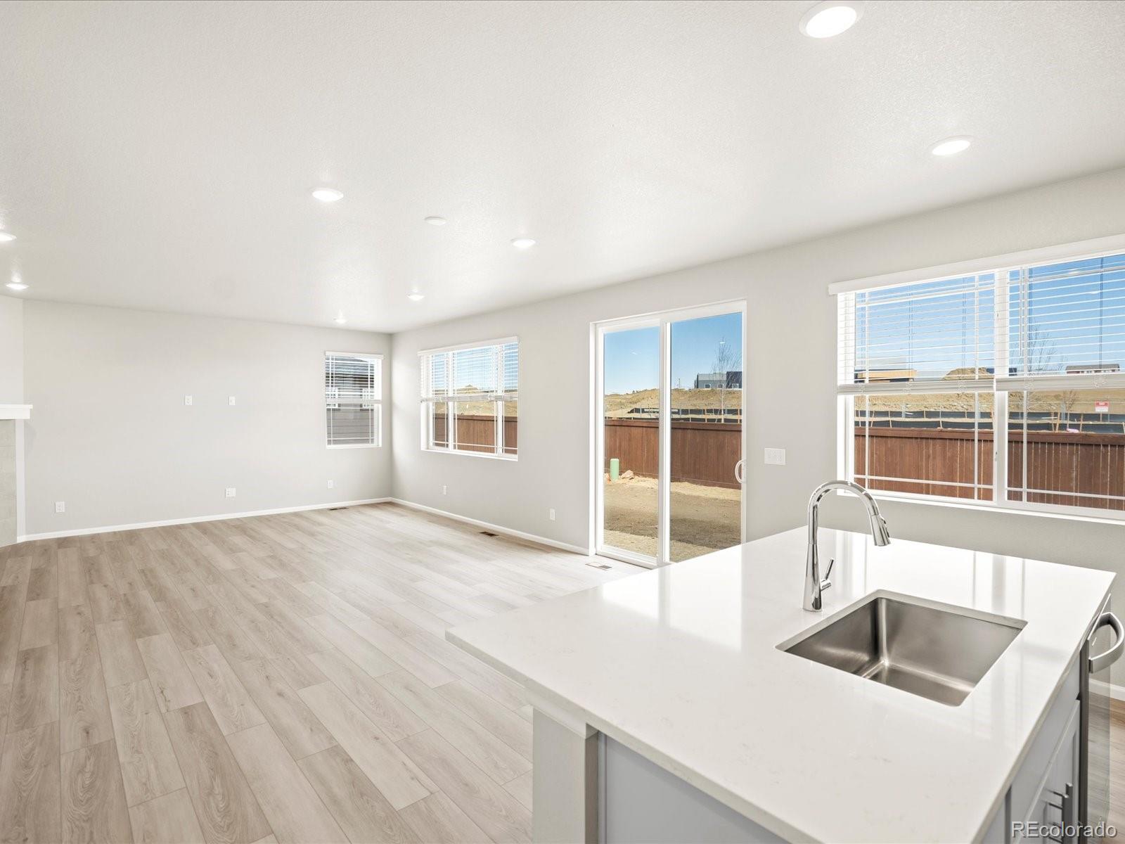 17517 East 89th Way Commerce City, CO 80022 - Photo 12 of 31 a kitchen with granite countertop a sink and a stove top oven