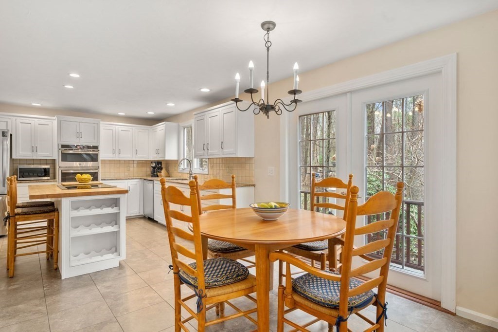 24 Parmenter Road Framingham, MA 01701 - Photo 14 of 42 a dining area with a table chairs and a kitchen view