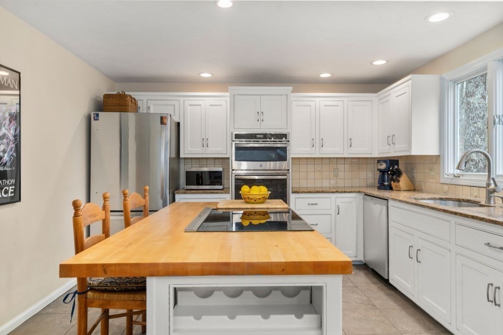 24 Parmenter Road Framingham, MA 01701 - Photo 18 of 42 a kitchen with stainless steel appliances kitchen island sink refrigerator and stove