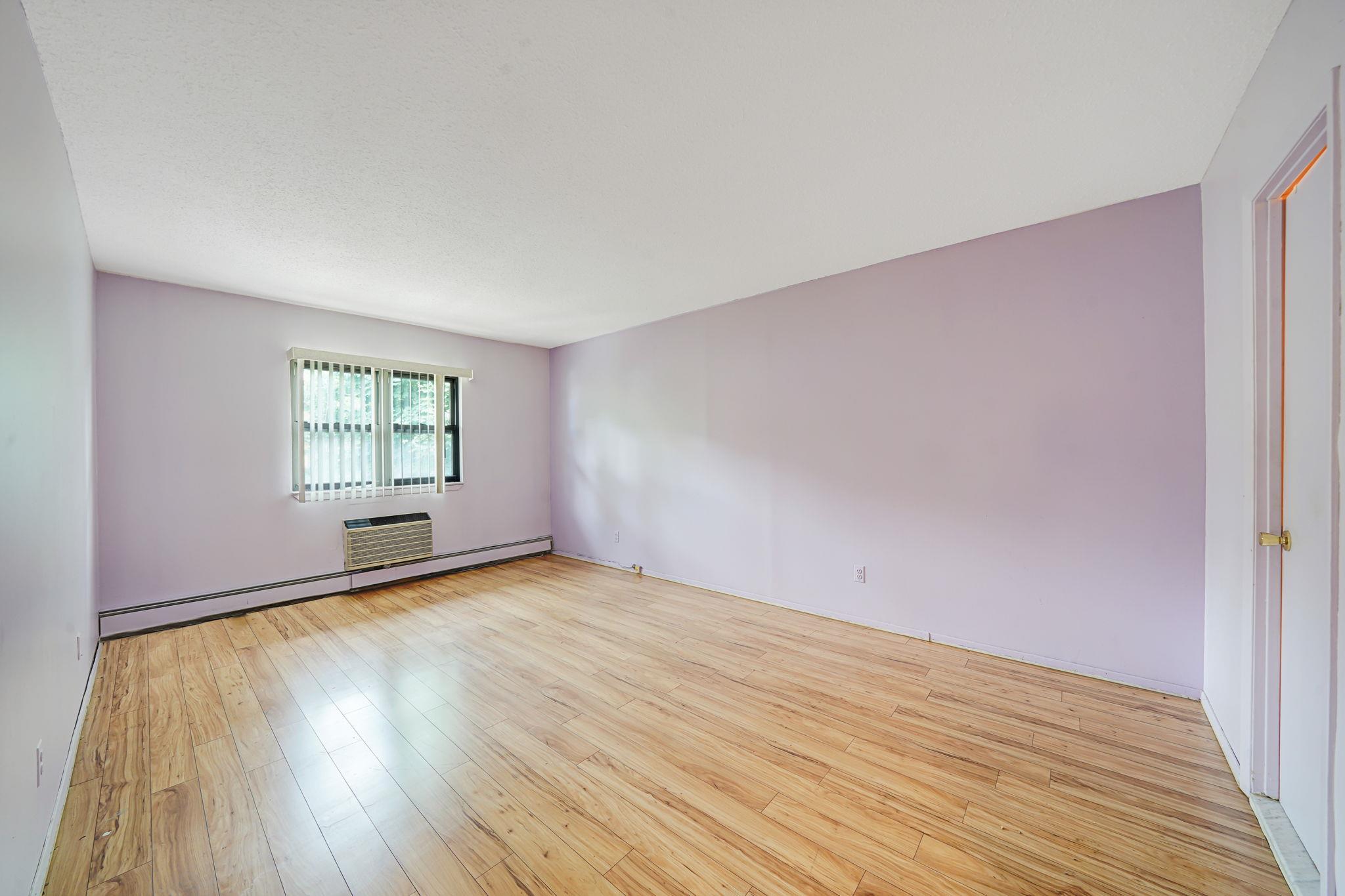 504 Julius Road, Unit 7C Queens, NY 11356 - Photo 12 of 22 a view of an empty room with wooden floor and a window