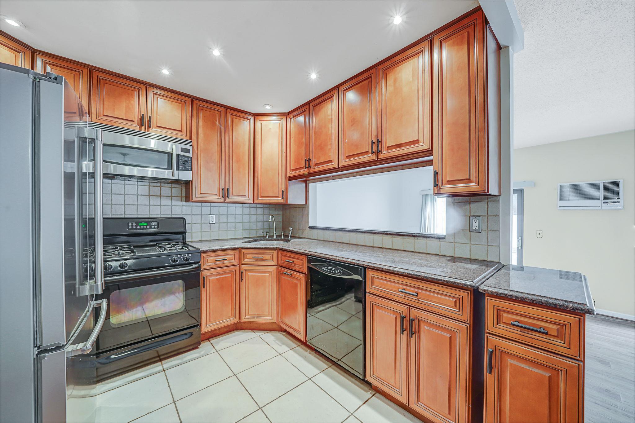 504 Julius Road, Unit 7C Queens, NY 11356 - Photo 3 of 22 a kitchen with stainless steel appliances granite countertop a refrigerator and a sink