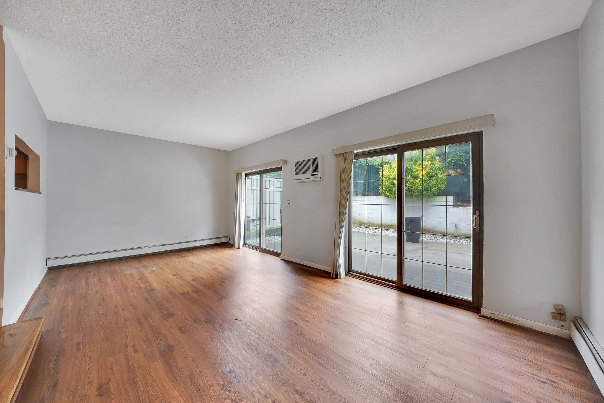 504 Julius Road, Unit 7C Queens, NY 11356 - Photo 7 of 22 a view of an empty room with wooden floor and a window