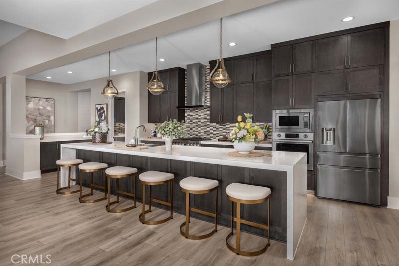 6505 Canyon Oaks Drive Simi Valley, CA 93063 - Photo 7 of 22 a kitchen with stainless steel appliances granite countertop a table chairs stove and kitchen island