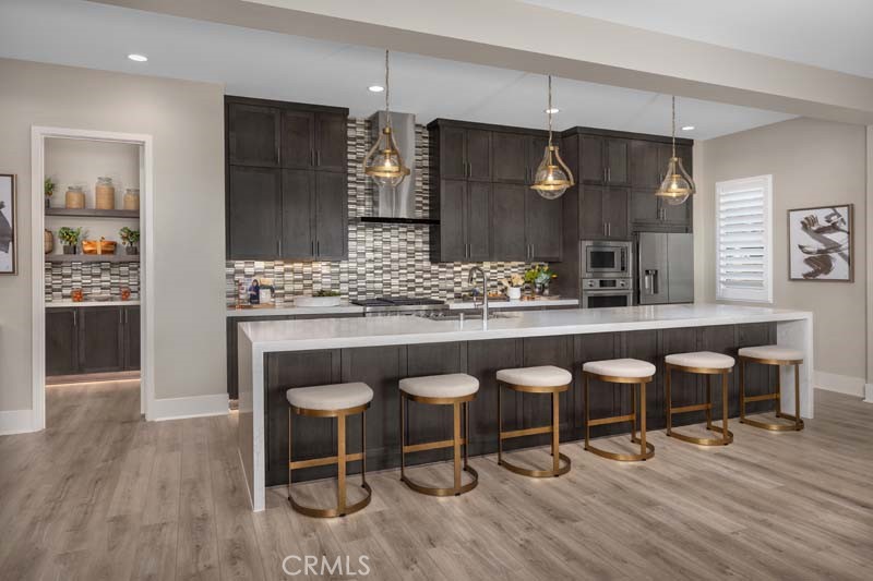 6505 Canyon Oaks Drive Simi Valley, CA 93063 - Photo 8 of 22 a kitchen with granite countertop a table chairs sink and wooden floor