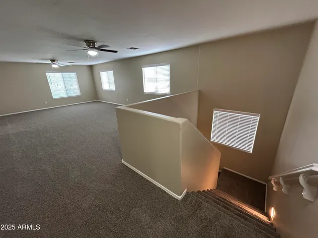 a view of an empty room with windows and chandelier