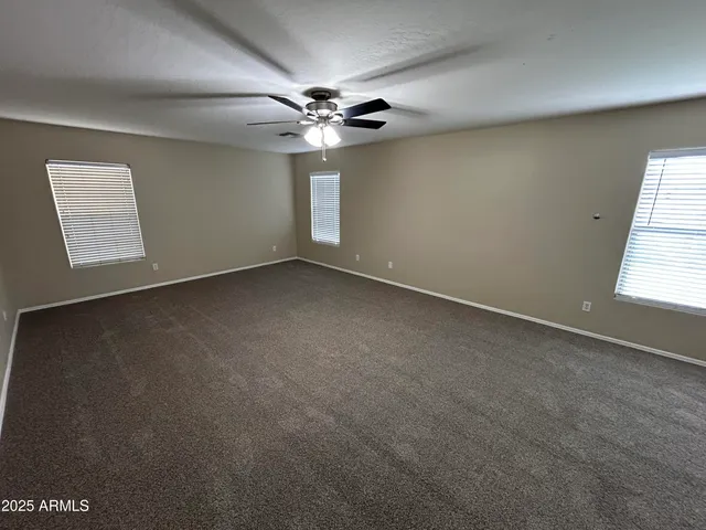 an empty room with a window and a fan