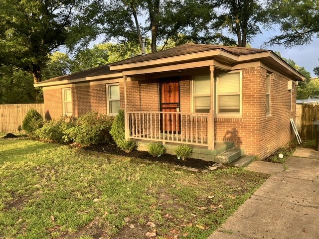 170 Wilson Street Collierville, TN 38017 - Photo 2 of 2 Brick exterior featuring a covered front porch with wood railings, a wood-finish front door, and mature landscaping