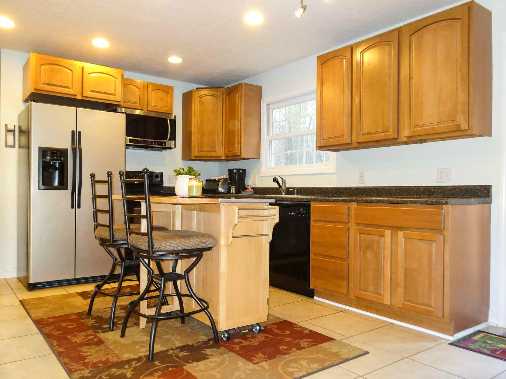 749 Isolane Road Callaway, VA 24067 - Photo 8 of 38 a kitchen with stainless steel appliances granite countertop a refrigerator a stove a sink and white cabinets with wooden floor