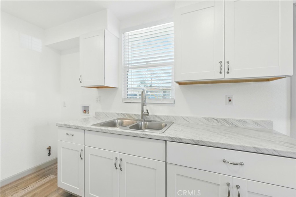 38833 9th Street East Palmdale, CA 93550 - Photo 8 of 28 a kitchen with granite countertop white cabinets and a sink