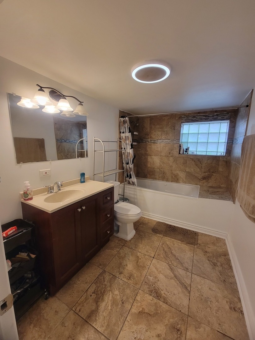 3705 West 65th Place Chicago, IL 60629 - Photo 19 of 31 a bathroom with a sink a toilet and mirror