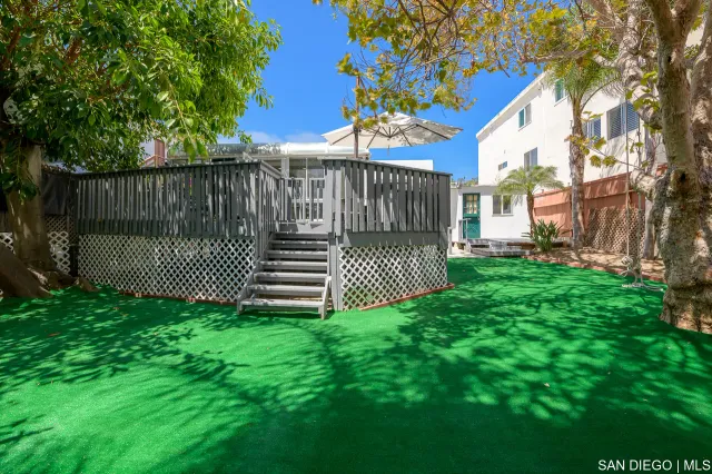 a view of a house with backyard and deck