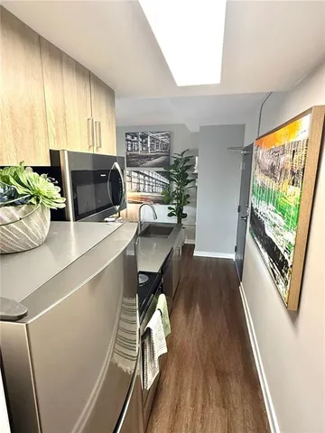 a kitchen with granite countertop a stove a sink a dining table and chairs