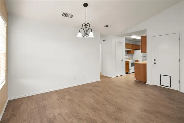 a view of a kitchen with a sink and dishwasher a refrigerator with wooden floor